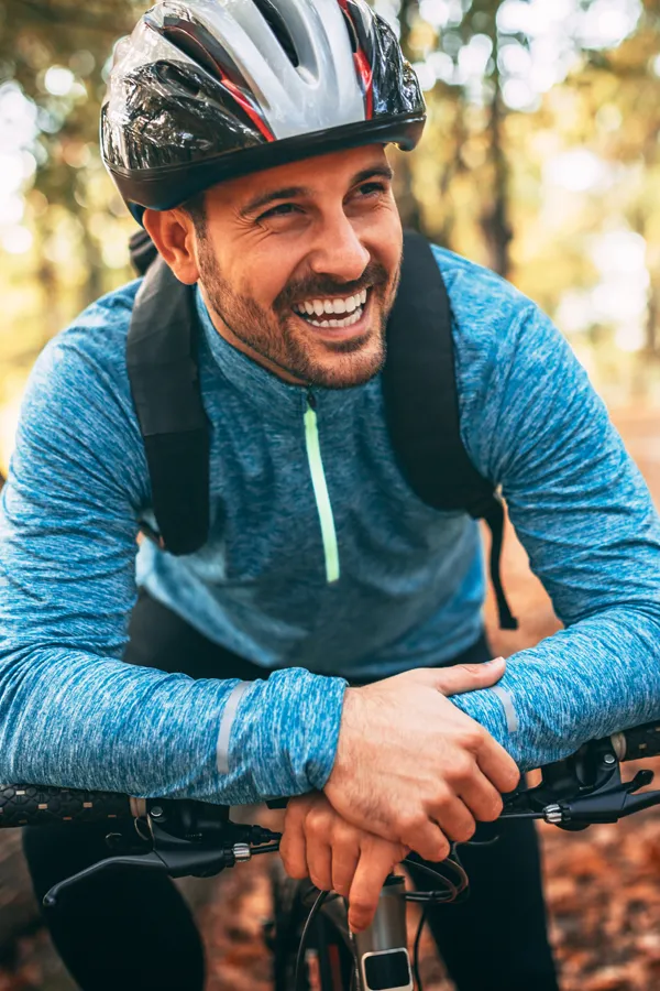 Adrenal-Hormone-Disorder-Treatment A smiling man getting ready for a cycling trip. Get treatment for adrenal hormone disorder from Pierre Rojas, DO in South Lyon.