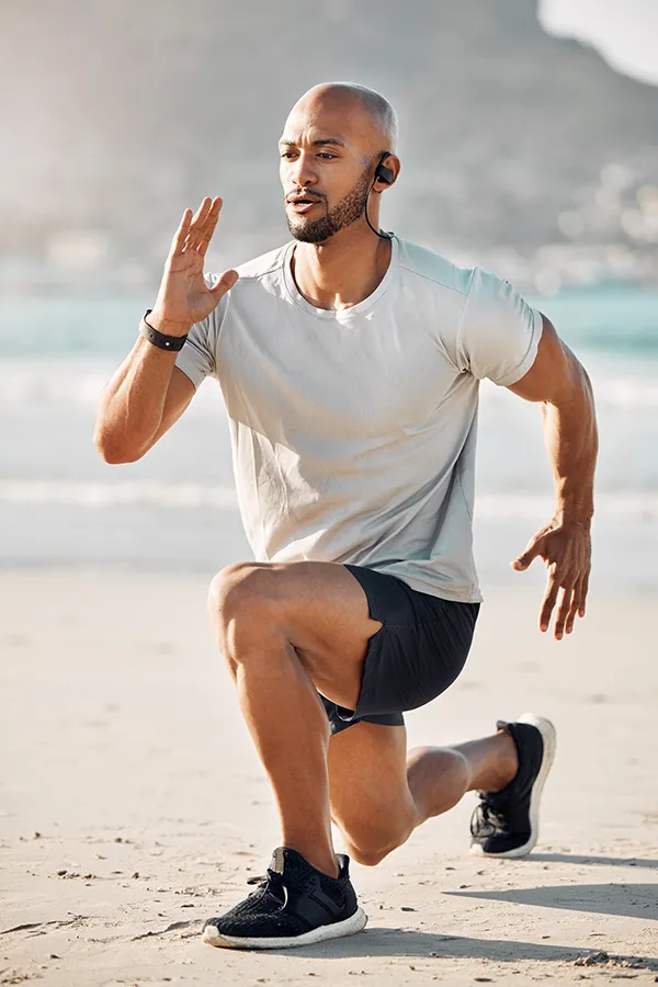 MCL-Tears-Treatment A man does lunges on the beach. Get treatment for MCL tears from Pierre Rojas, DO in South Lyon.