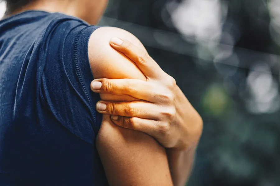 PRP-for-Shoulder-Injury-Doctor Close up of a woman in a tank top holding her shoulder in pain, which can be relieved by PRP treatment for shoulder pain from Pierre Rojas, DO in South Lyon.