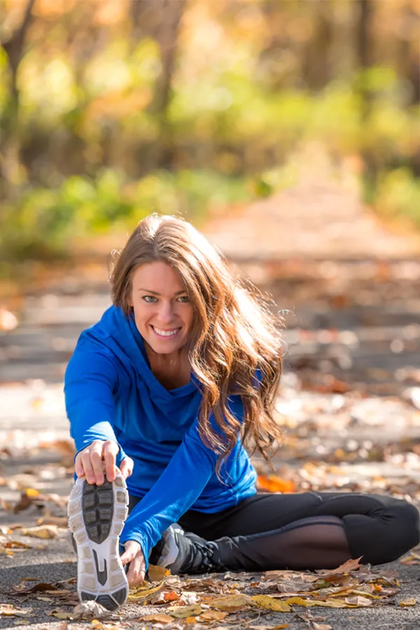 Sermorelin-Treatment A healthy woman in blue sweats stretches on a trail before a run. Get Sermorelin peptide therapy from Pierre Rojas, DO in South Lyon.