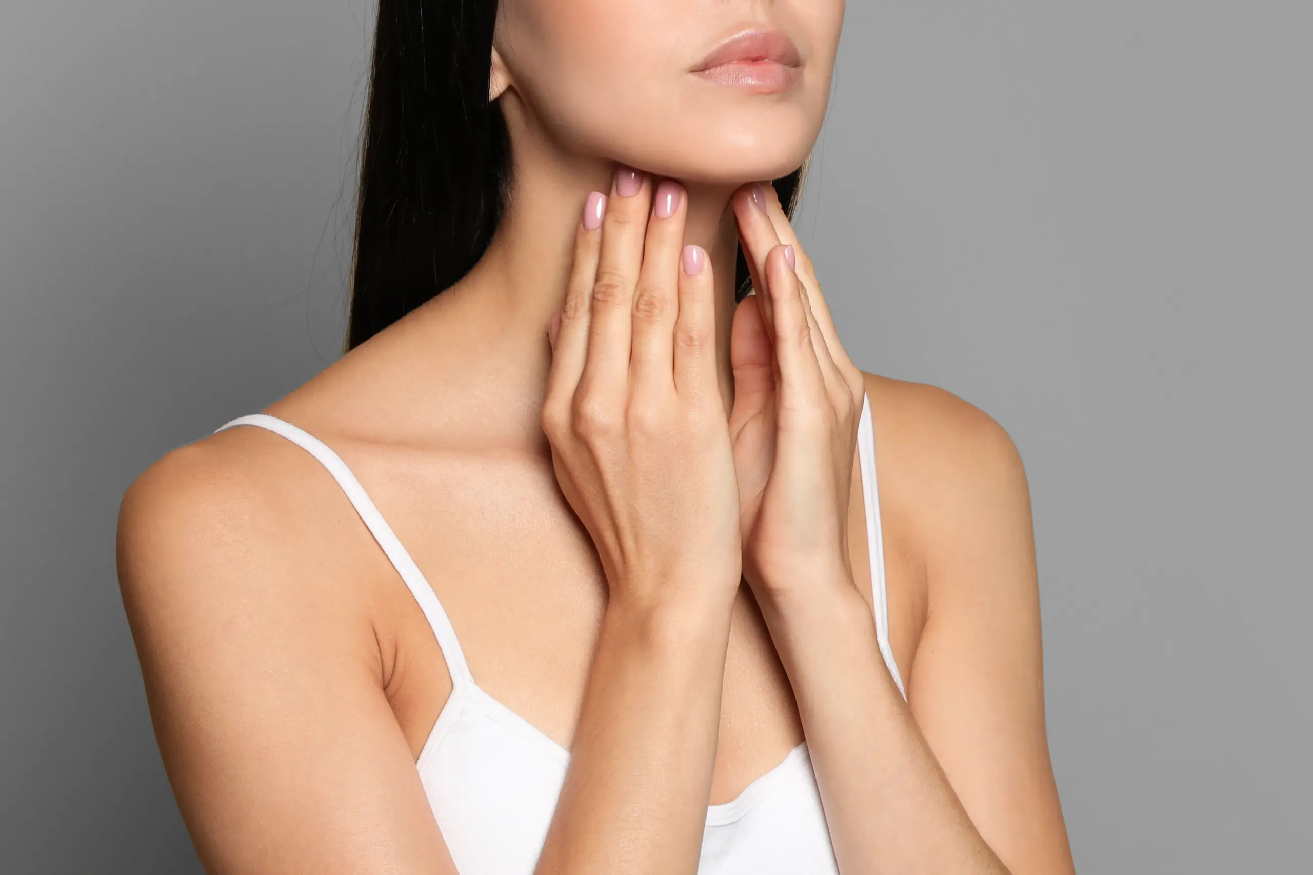 Thyroid-Doctor A woman in a white tank top touches her neck looking for signs of thyroid disorder. Get help for thyroid disorders from Pierre Rojas, DO in South Lyon.
